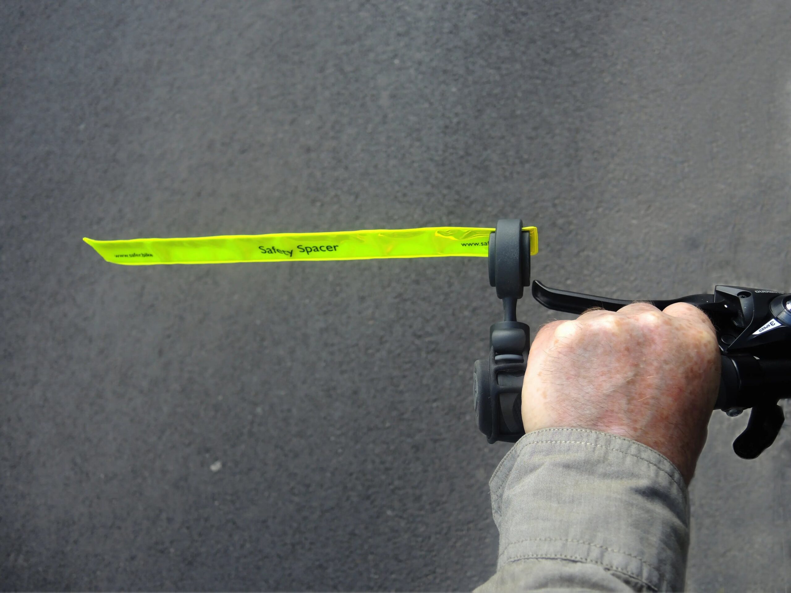 Radfahrende haben ihren Abstandhalter am Lenker immer im Blick. Die professionelle Lösung: Unser Fahrrad Abstandshalter Safety Spacer Snap Band in neongelb, montiert am Lenker, um anderen Verkehrsteilnehmern den notwendigen Sicherheitsabstand für Radfahrer beim Überholen zu signalisieren.