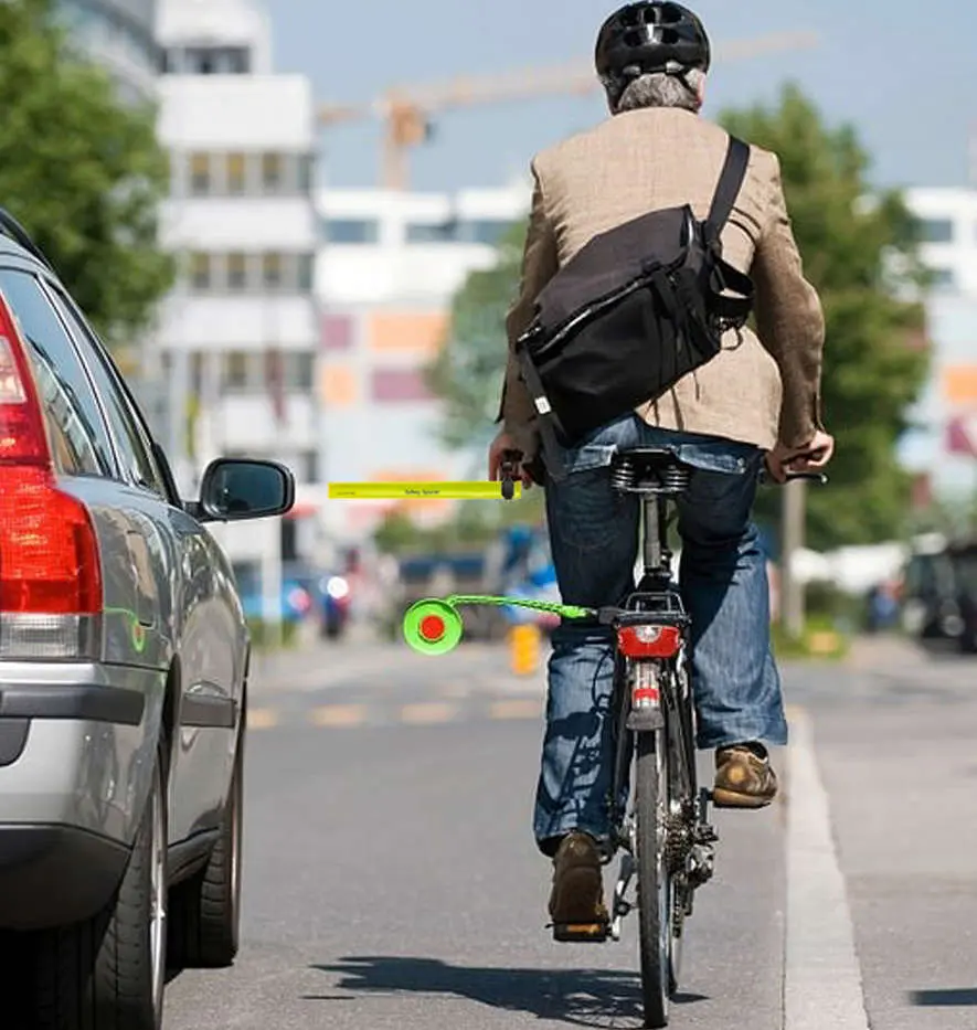 A cyclist uses a flexible rod with a disc at the end as an alternative device for maintaining a safe distance.