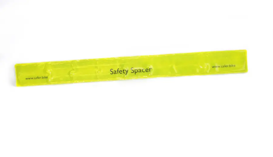 The Safety Spacer's high-reflectivity Snap Band is shown fully extended and straight, ready to be inserted into the mount to create a visual cue for a safe passing distance.
