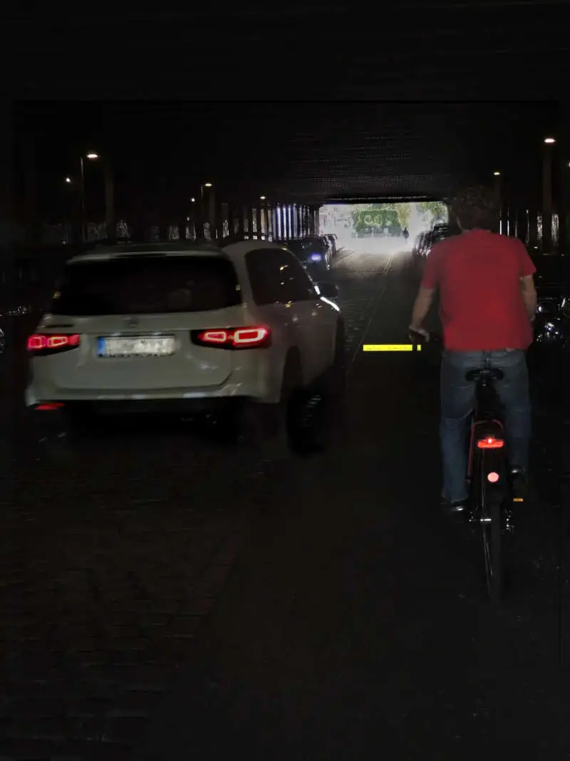 Radfahrer nutzt den reflektierenden Fahrrad Abstandshalter für mehr Sichtbarkeit bei Nacht in einer dunklen Unterführung neben einem überholenden Auto.
Schaffen Sie mehr Sicherheit im Straßenverkehr! Der flexible Fahrrad Abstandshalter für die Sicherheit Ihrer Fahrräder ist die flexible, hochreflektierende Distanzmarkierung für jedes Fahrrad. Das Safety Spacer Snap Band ist einfach zu montieren, kompakt und effektiv. Jetzt kaufen für mehr Sicherheit auf der Straße!
